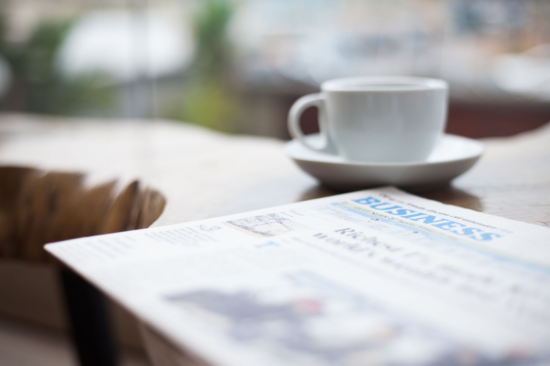 Finansavis og en kop kaffe på et bord